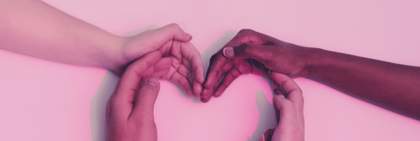 Hands forming a heart on a pink background, symbolizing love and affection.